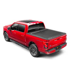 Roll-N-Lock A-Series black powder-coated aluminum retractable tonneau cover installed on a Ford F-150 truck bed.