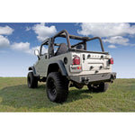 Textured black Rugged Ridge XHD modular rear bumper with dual D-ring recovery points for Jeep Wrangler and CJ.