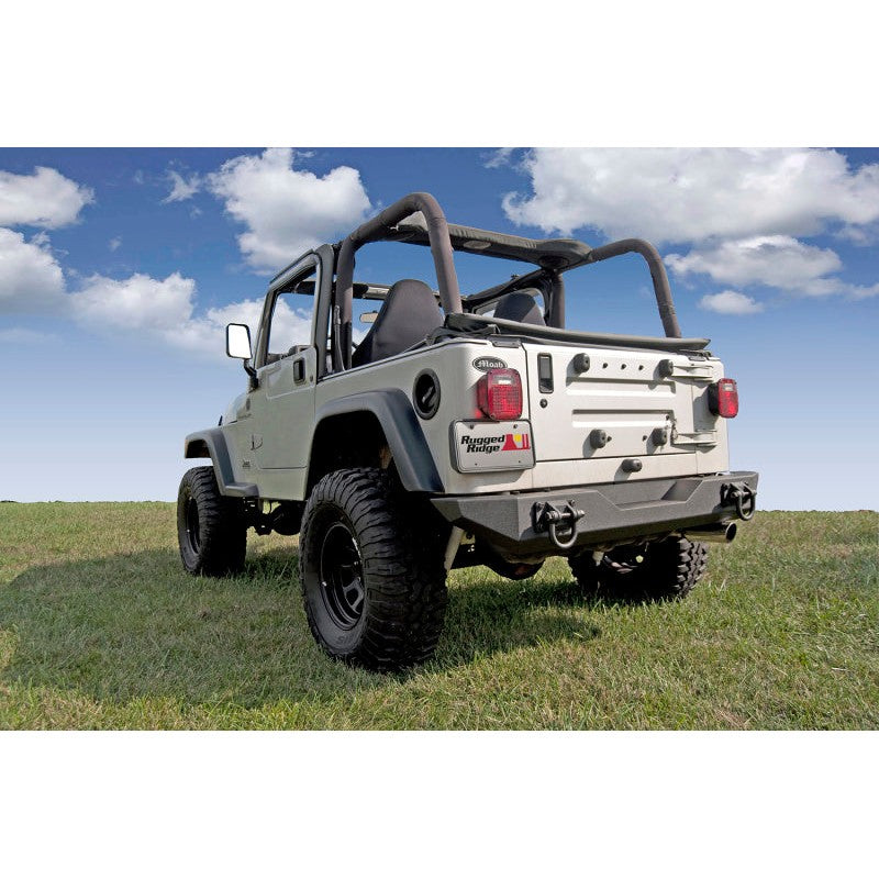 Textured black Rugged Ridge XHD modular rear bumper with dual D-ring recovery points for Jeep Wrangler and CJ.