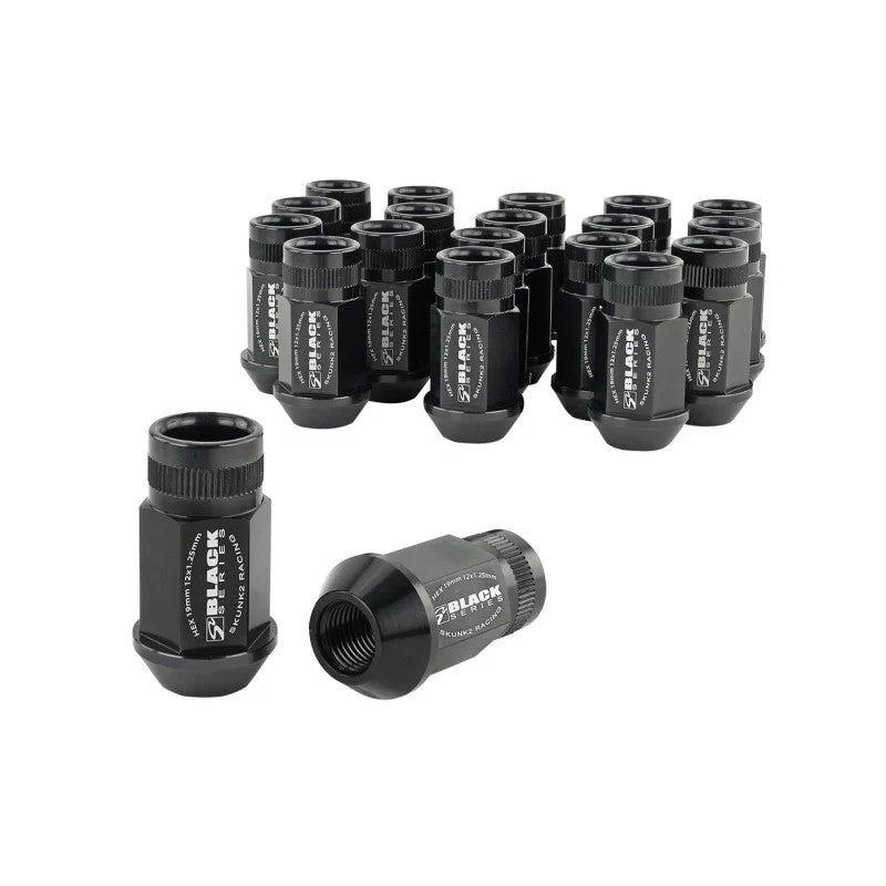 Set of 20 Skunk2 black anodized forged 7075 aluminum lug nuts with knurled ends and M12x1.25 threads.