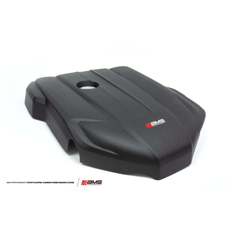 Glossy 2x2 weave carbon fiber engine cover with AMS Performance branding for 2020-2021 Toyota GR Supra B58.