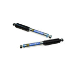 Superlift 95030 dual steering stabilizer kit featuring two Bilstein 5100 cylinders with black boots and bushings.