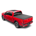 TruXedo Lo Pro black leather-grain vinyl roll-up tonneau cover installed on a 2015-2025 Ford F-150 pickup truck bed.